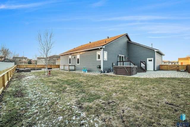 rear view of property featuring a patio, a yard, a fenced backyard, and a hot tub