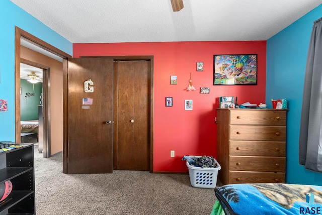 bedroom with a textured ceiling, a closet, a ceiling fan, and carpet flooring