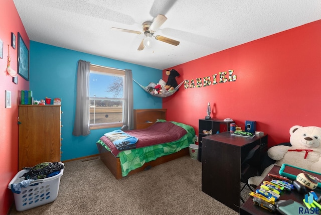 carpeted bedroom with a ceiling fan, a textured ceiling, and baseboards