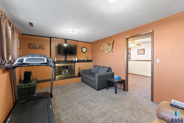 workout room featuring carpet, a fireplace, visible vents, and a textured ceiling