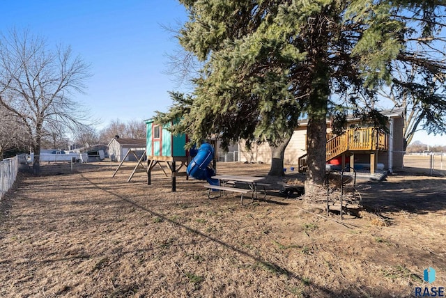 view of yard featuring a fenced backyard, playground community, and stairway