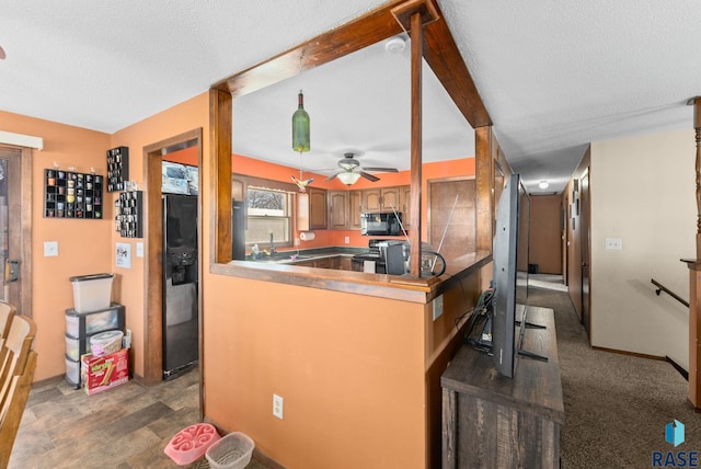 kitchen with a ceiling fan, brown cabinetry, a textured ceiling, a peninsula, and black appliances