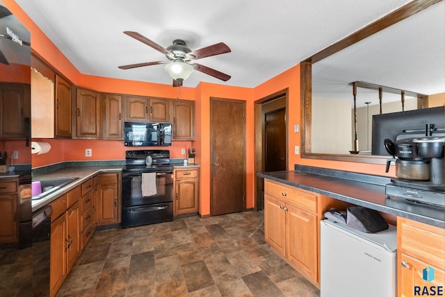 kitchen featuring black appliances, stone finish floor, dark countertops, and brown cabinets