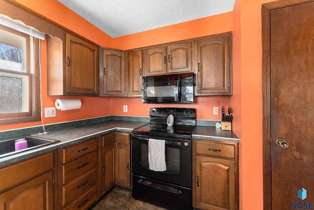 kitchen with dark countertops, black appliances, and brown cabinets