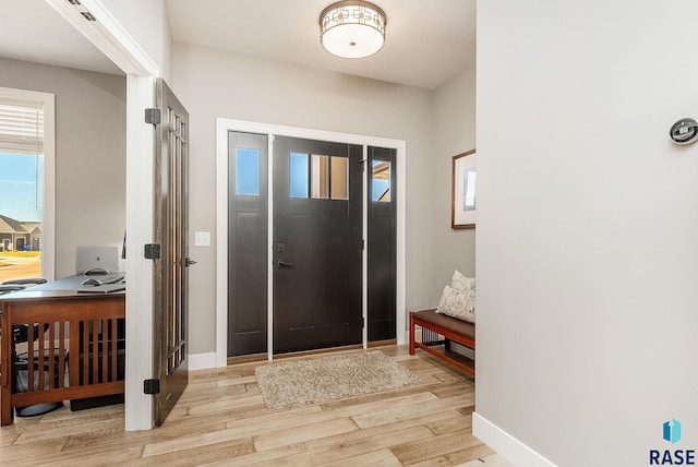 entryway with light wood-style flooring and baseboards