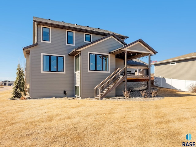 back of property featuring stairs, a yard, fence, and a wooden deck