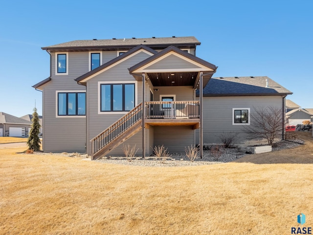 rear view of property featuring a lawn and stairs