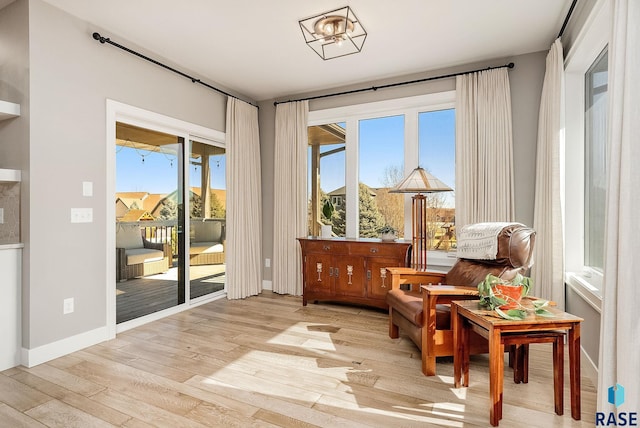 living area featuring light wood-style floors and baseboards