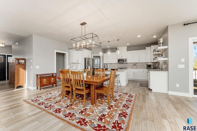 dining room featuring light wood-style floors, recessed lighting, and baseboards