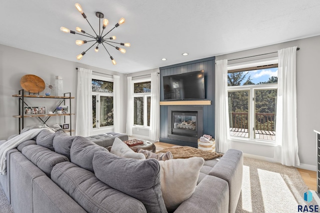 living area featuring recessed lighting, a notable chandelier, a fireplace, and baseboards