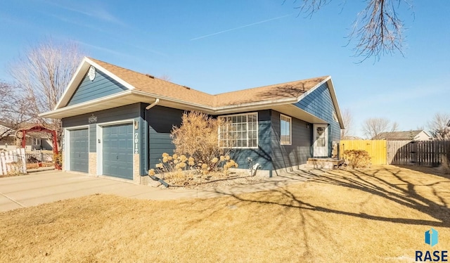 view of property exterior with concrete driveway, fence, an attached garage, and a gate