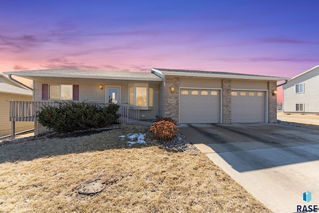 ranch-style home featuring an attached garage, a porch, and concrete driveway