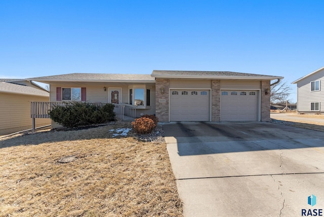 single story home featuring covered porch, brick siding, driveway, and an attached garage