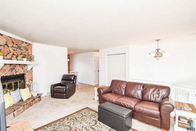 living room with a textured ceiling, a stone fireplace, carpet flooring, and an inviting chandelier