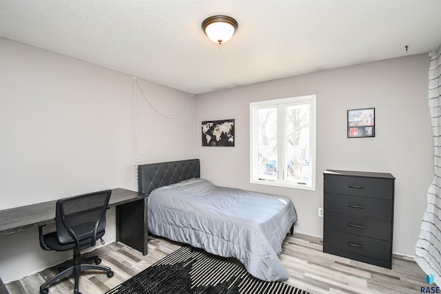 bedroom with light wood-style flooring and a textured ceiling