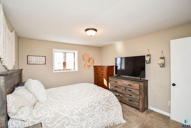 carpeted bedroom featuring a textured ceiling and baseboards