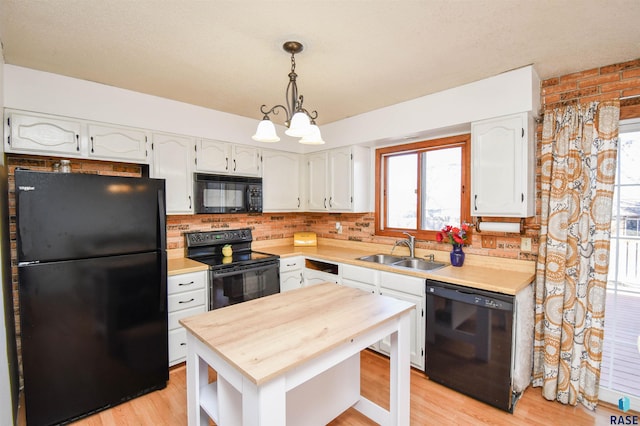 kitchen featuring white cabinetry, a sink, black appliances, and wooden counters