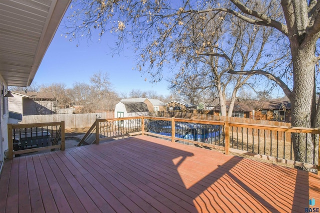 wooden deck with a fenced backyard, a residential view, and an outdoor structure