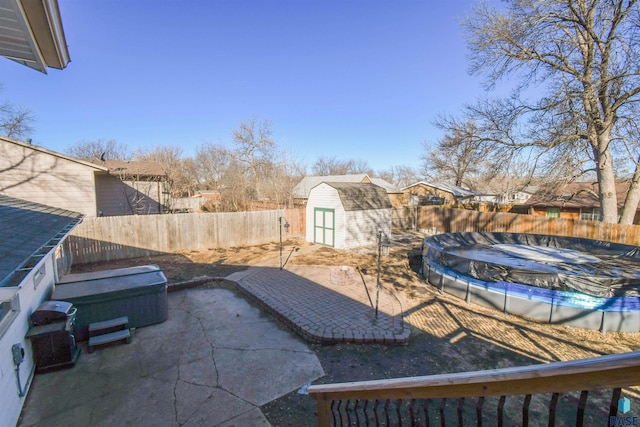 view of patio with a fenced in pool, a fenced backyard, an outdoor structure, and a storage shed