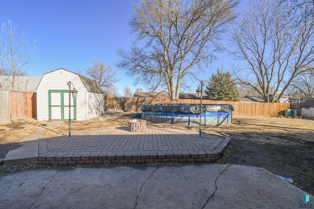 view of patio with a storage shed, an outbuilding, and a fenced backyard