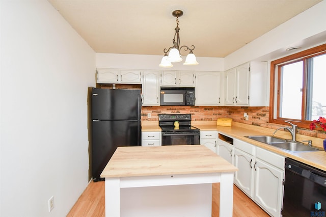 kitchen with backsplash, white cabinetry, a sink, wood counters, and black appliances