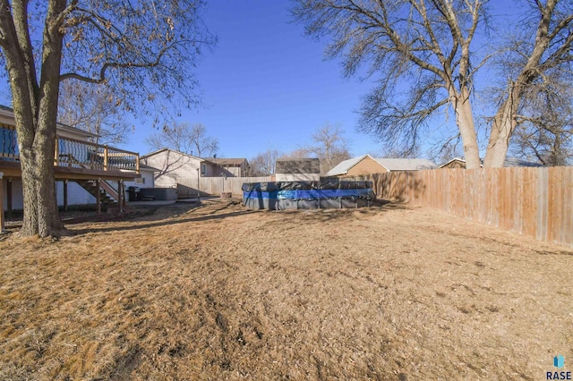 view of yard featuring stairway, a fenced in pool, a fenced backyard, and a deck