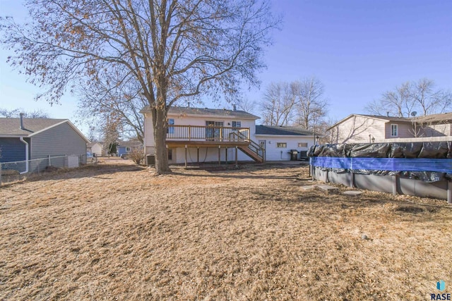 back of house with stairs, a covered pool, a wooden deck, and fence