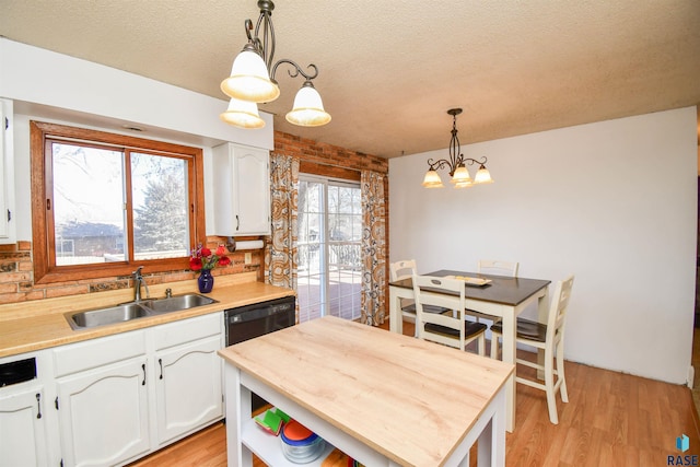 kitchen with butcher block countertops, white cabinetry, a sink, and light wood-style flooring