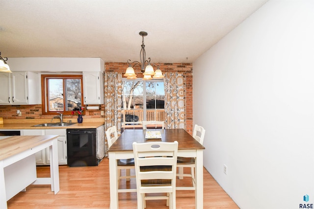 kitchen featuring plenty of natural light, white cabinets, dishwasher, and a sink