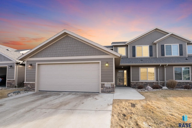 craftsman house featuring stone siding, an attached garage, and driveway