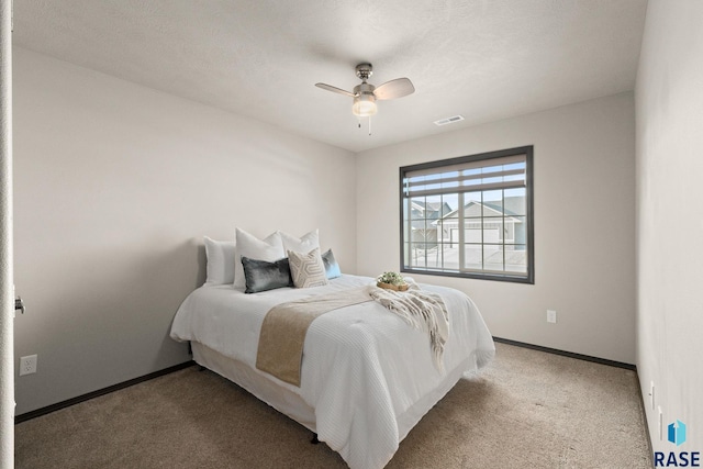 carpeted bedroom with a ceiling fan, visible vents, and baseboards