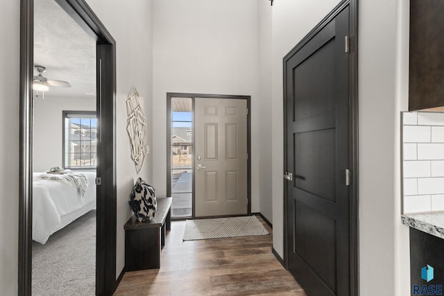 entrance foyer with a ceiling fan, baseboards, and wood finished floors