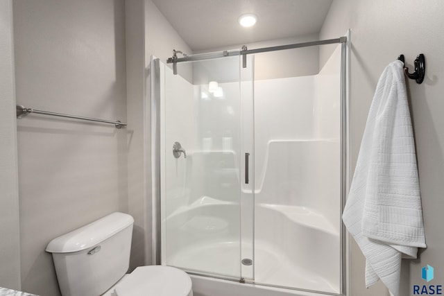 bathroom with toilet and a stall shower