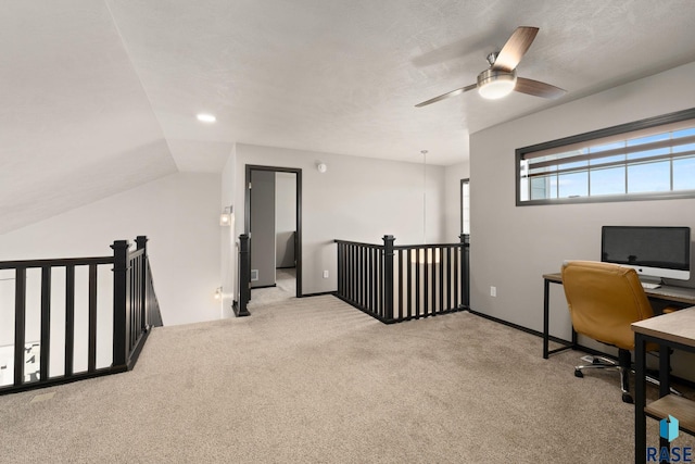 carpeted home office featuring vaulted ceiling and a textured ceiling