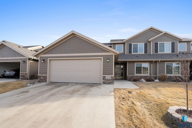 craftsman-style home featuring a garage, stone siding, and concrete driveway