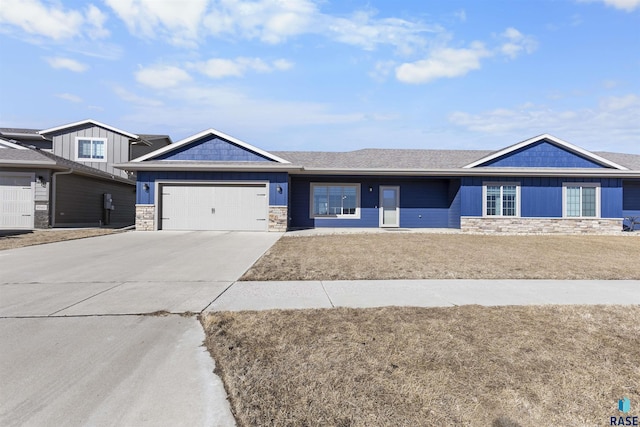 view of front of house with an attached garage, stone siding, board and batten siding, and concrete driveway