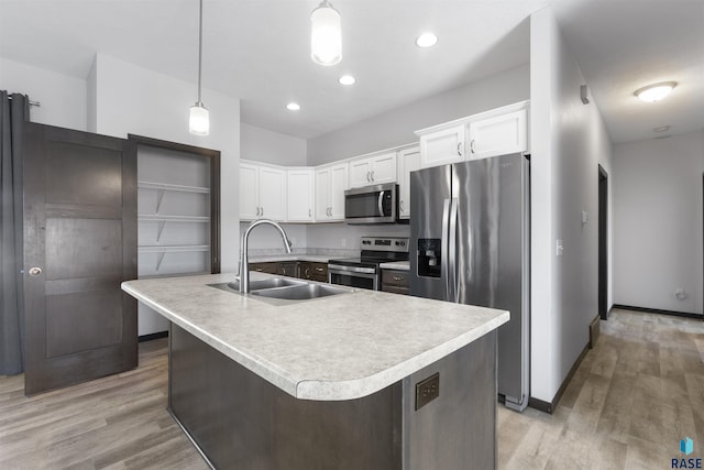 kitchen featuring a sink, light wood-style floors, white cabinets, light countertops, and appliances with stainless steel finishes