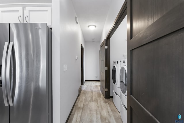 washroom featuring washing machine and dryer, laundry area, and light wood finished floors