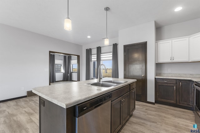 kitchen with appliances with stainless steel finishes, light countertops, white cabinets, and a sink