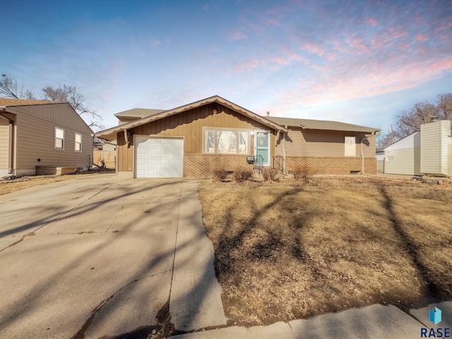 ranch-style house featuring a garage, brick siding, driveway, and board and batten siding