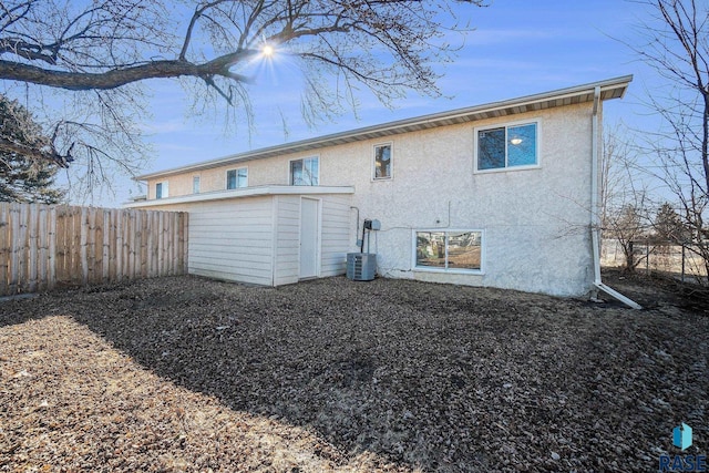 back of property featuring fence and stucco siding