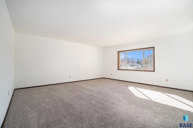 carpeted empty room with baseboards