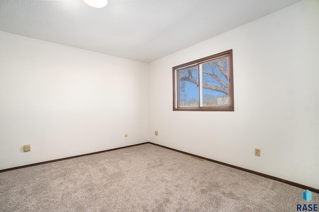 carpeted spare room with baseboards