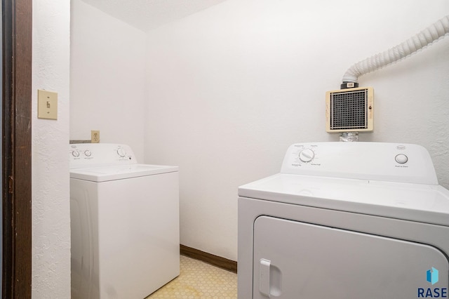 clothes washing area with light floors, laundry area, independent washer and dryer, and baseboards