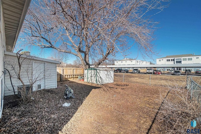 view of yard with fence and an outdoor structure