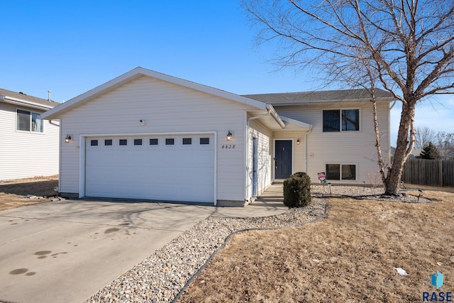 view of front of home featuring an attached garage, fence, and concrete driveway