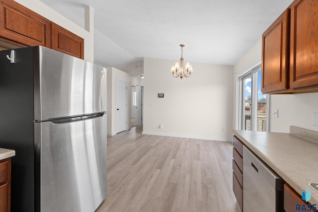 kitchen with lofted ceiling, dishwashing machine, brown cabinets, freestanding refrigerator, and light wood-type flooring