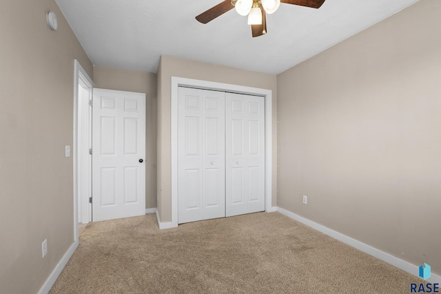 unfurnished bedroom with a ceiling fan, carpet, baseboards, and a closet