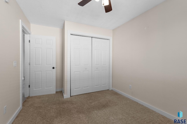 unfurnished bedroom with carpet, a closet, ceiling fan, and baseboards