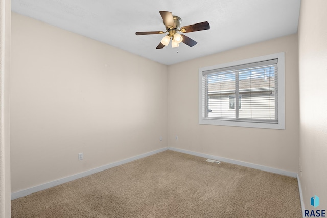 empty room with a ceiling fan, carpet, visible vents, and baseboards